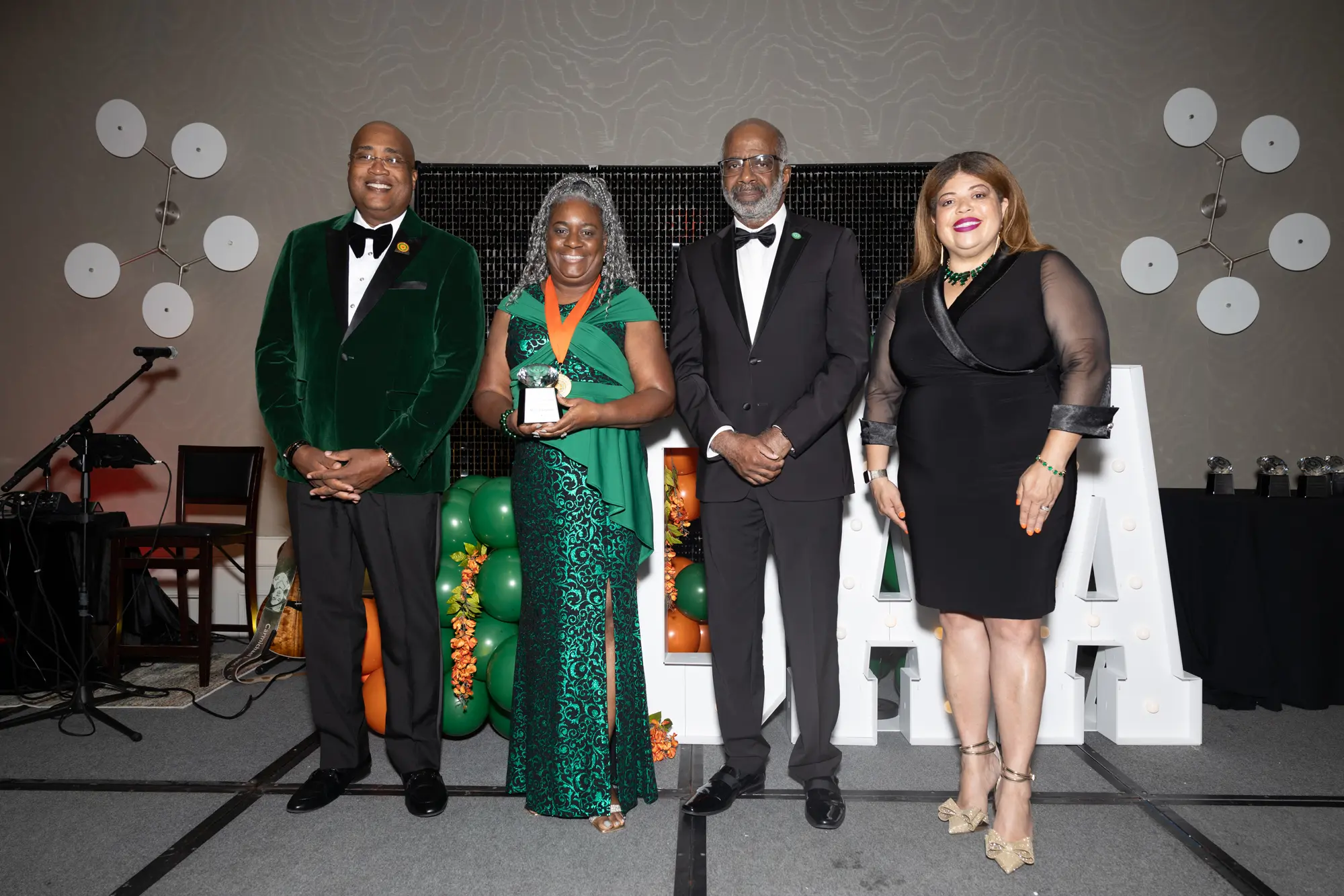 FAMU NAA President Curtis Johnson, Mildred Graham, FAMU President Larry Robinson and FAMU Board of Visitors Chair Kristin Harper stand together as Graham accepts her award. 