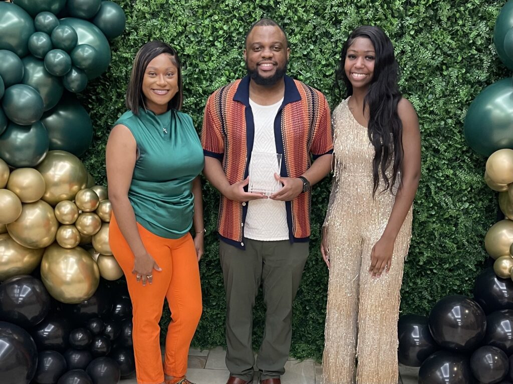 WANM-FM 90.5 staff members Alicia Adams, senior broadcast journalism student (left), and Jayla Royal (right), a spring 2025 public relations graduate, celebrate Ward’s recognition as “Advisor of the Year” during the FAMU COLAC Awards in April 2025.
