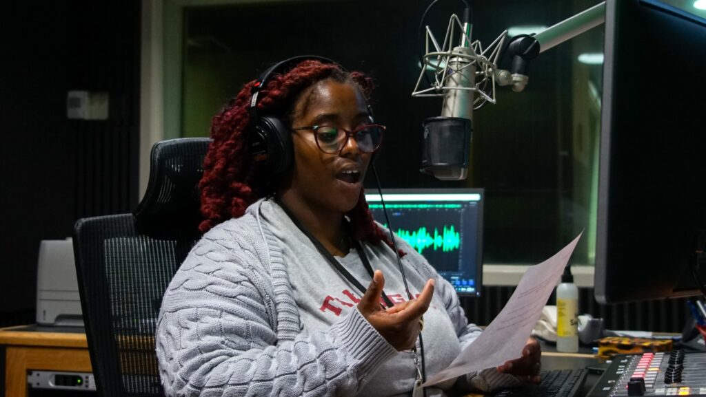 WFSU Producer Jason Acuna captures FAMU SJGC student Jazzmin Sutherland, a member of the Report for America summer internship program cohort, in action as she reads a script she wrote for a recent newscast. 