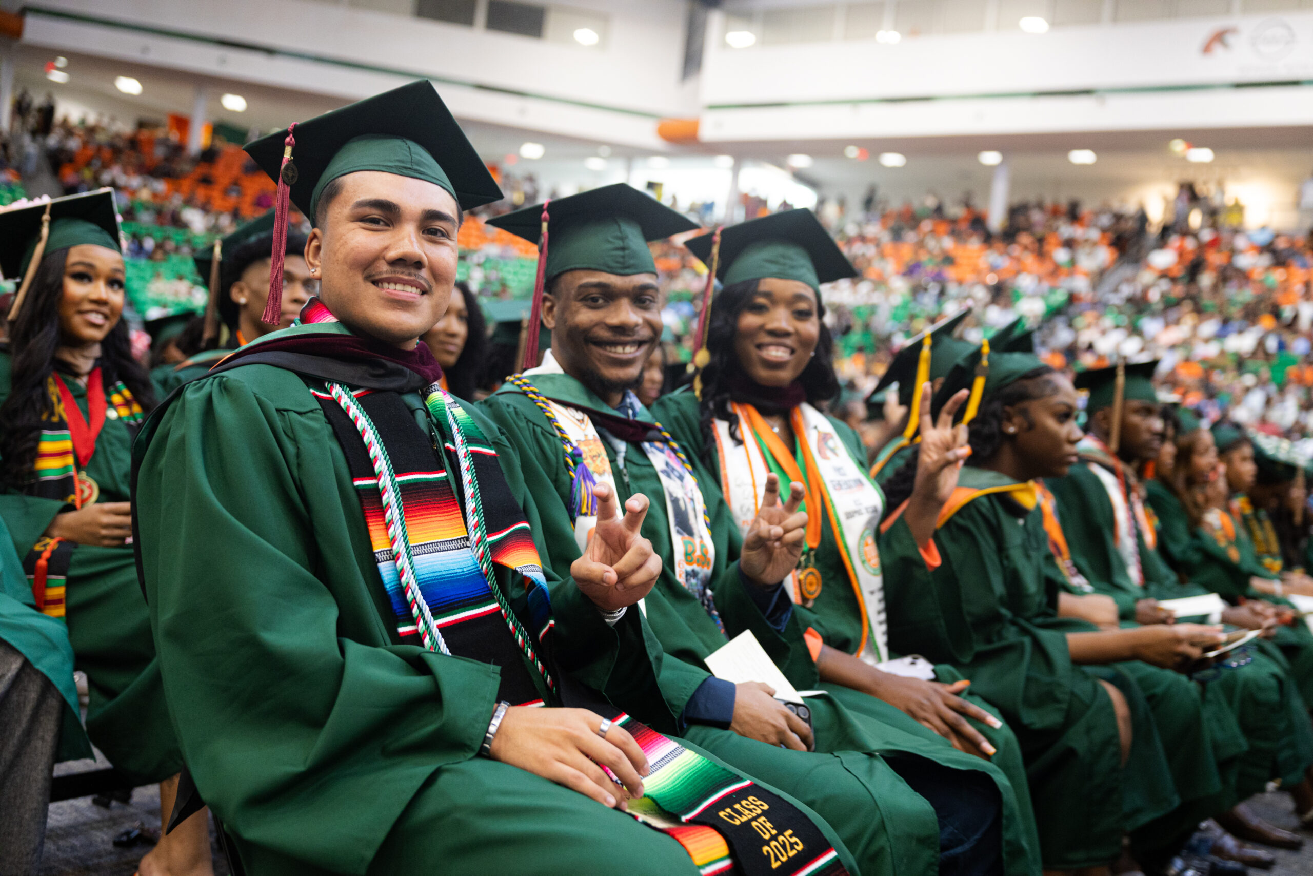 Arriaga shows his Rattler pride with fellow FAMU grads during the summer 2025 commencement ceremony, a history-making moment for his family.