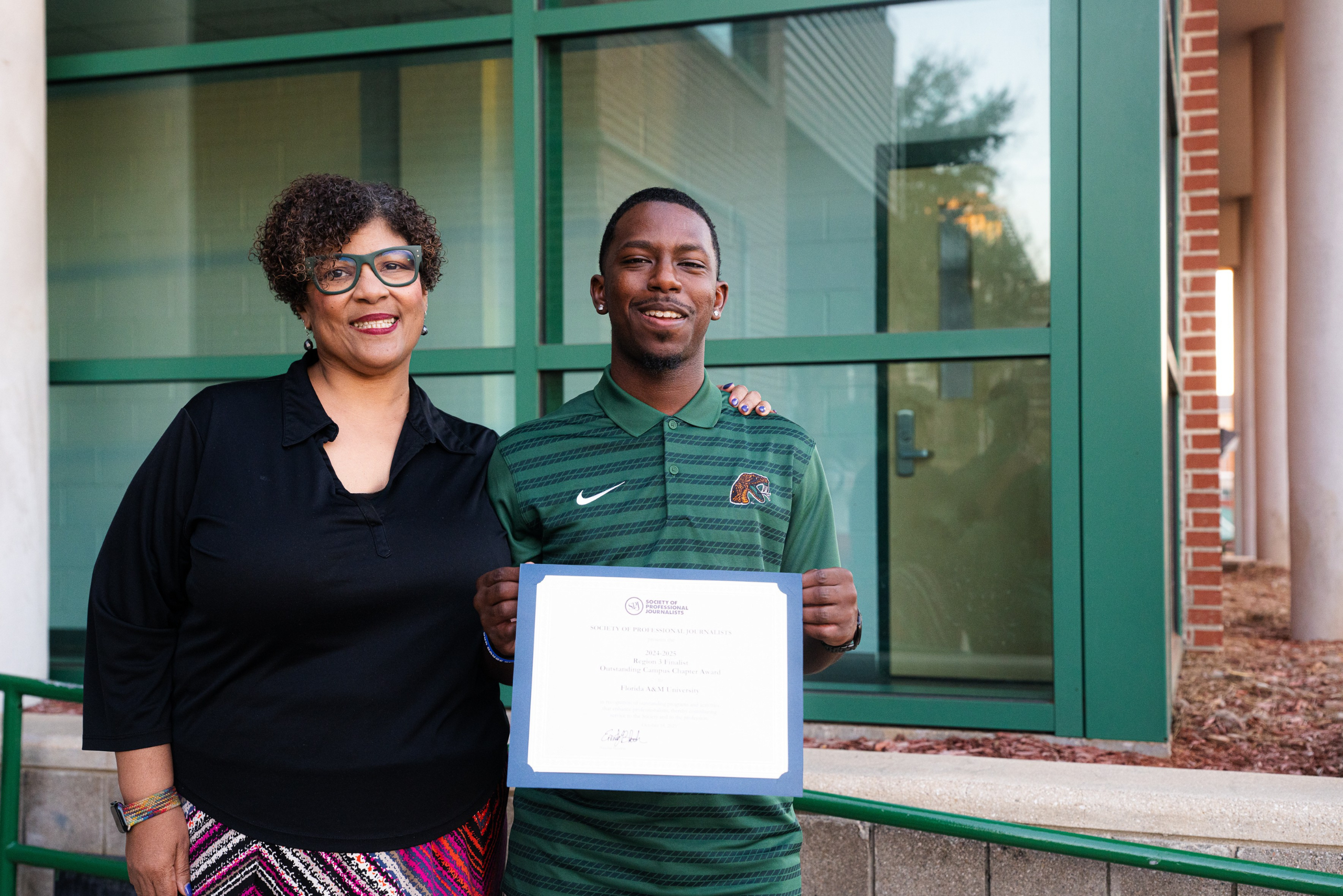 Professor Hunter and student Michael Trim Jr proudly display one of the certificates the FAMU SPJ chapter received in recognition of its accomplishments. Photo: Justyn Thomas.