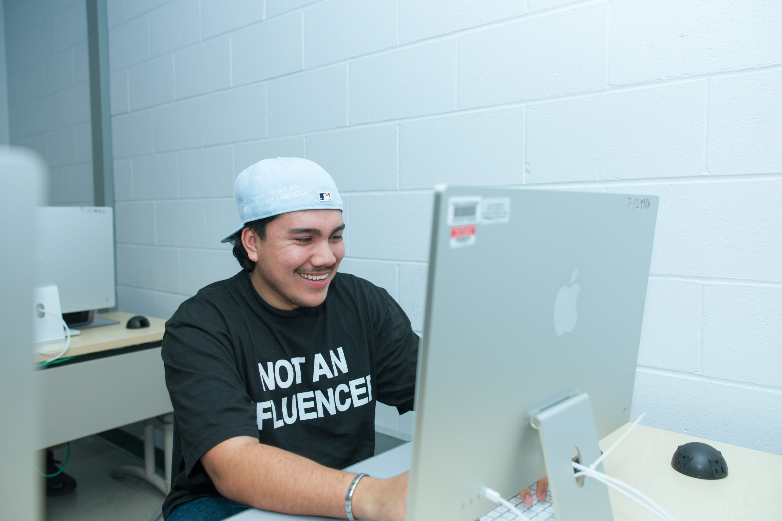 Arriaga enjoys an intensive design workshop facilitated by FAMU SJGC professors. He is seen wearing a t-shirt he helped to design for an apparel brand.